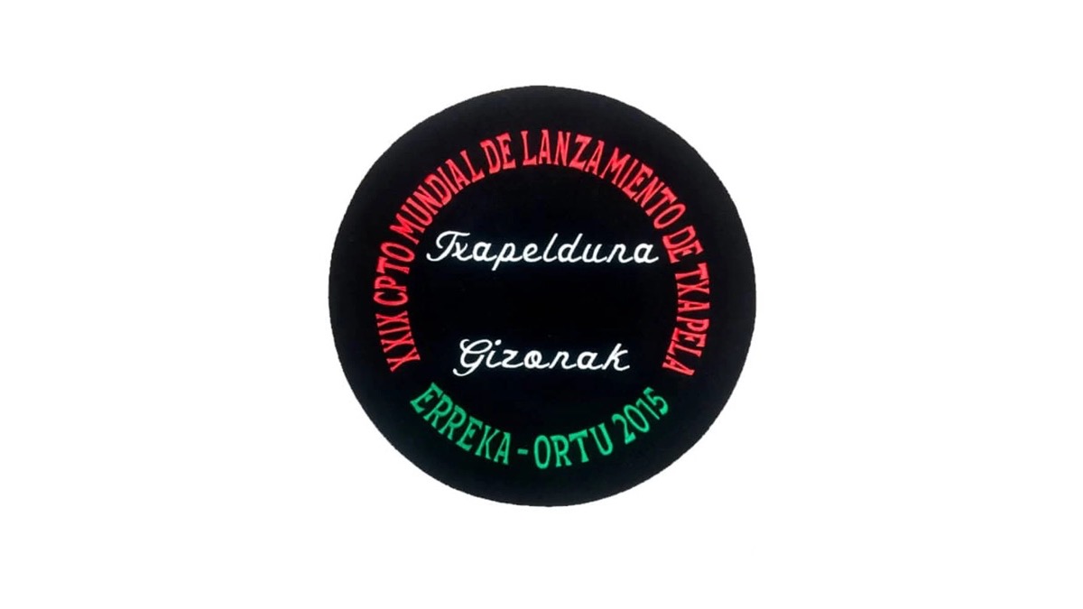 Txapela negra bordada con el nombre de un campeonato en arco, la palabra Txapelduna y el lugar y el año